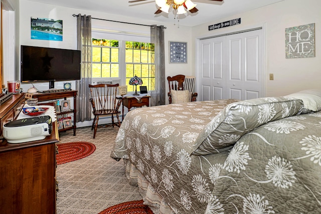 bedroom with ceiling fan, carpet floors, and a closet