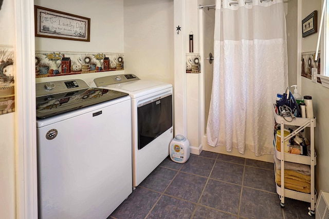 clothes washing area with washing machine and dryer and dark tile patterned floors