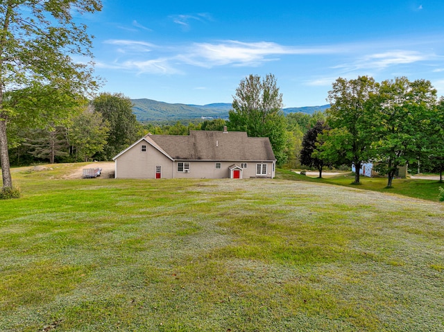 exterior space with a mountain view and a yard