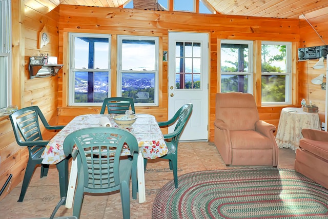 tiled dining room featuring a wealth of natural light, wood walls, wooden ceiling, and vaulted ceiling