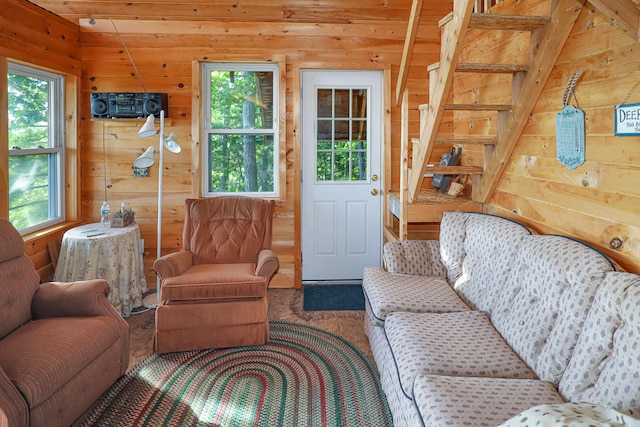 living room with lofted ceiling, a wealth of natural light, wooden ceiling, and wood walls