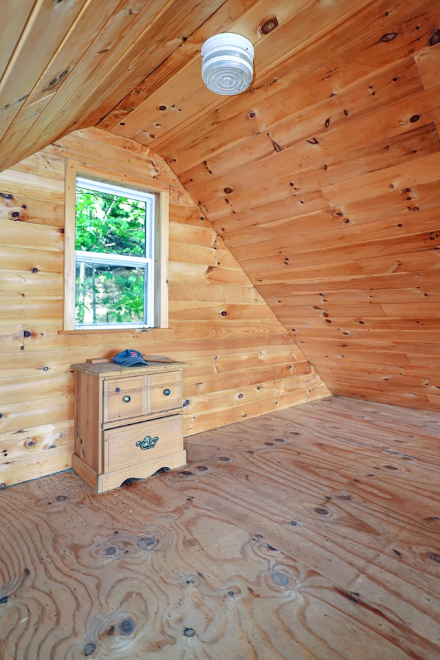 additional living space with lofted ceiling and wooden walls