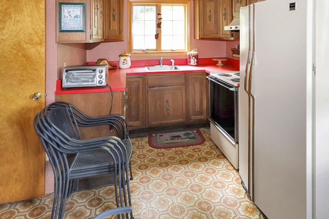 kitchen with premium range hood, electric stove, sink, and white refrigerator