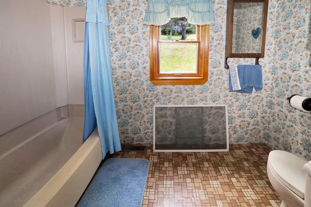 bathroom featuring toilet and shower / bath combo with shower curtain