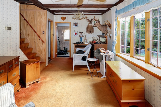 living area featuring beamed ceiling, light carpet, and an inviting chandelier