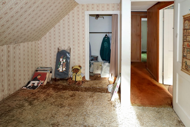 interior space featuring wood walls, carpet floors, and vaulted ceiling