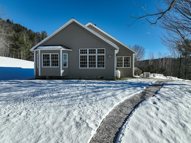 snow covered house with central air condition unit