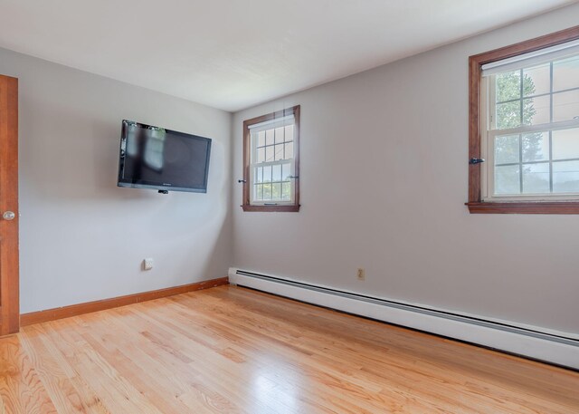 empty room featuring light hardwood / wood-style flooring and a baseboard heating unit