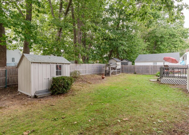 view of yard featuring a wooden deck and a storage shed