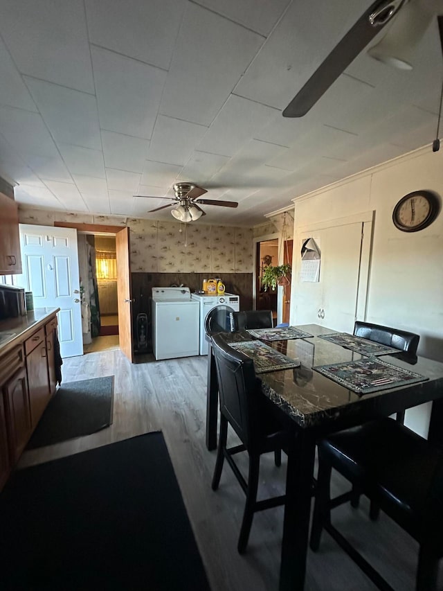 dining space featuring ceiling fan, washing machine and clothes dryer, and light hardwood / wood-style flooring