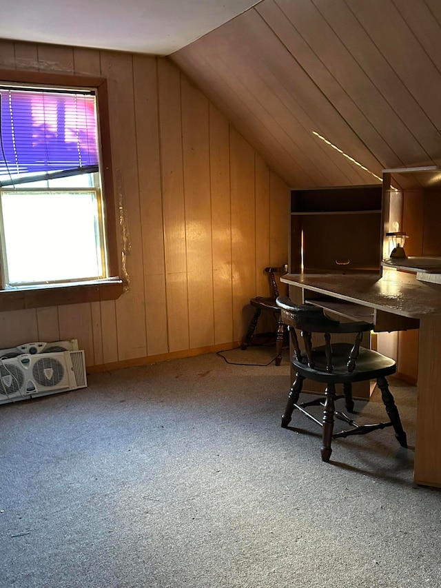 carpeted office featuring lofted ceiling and wood walls