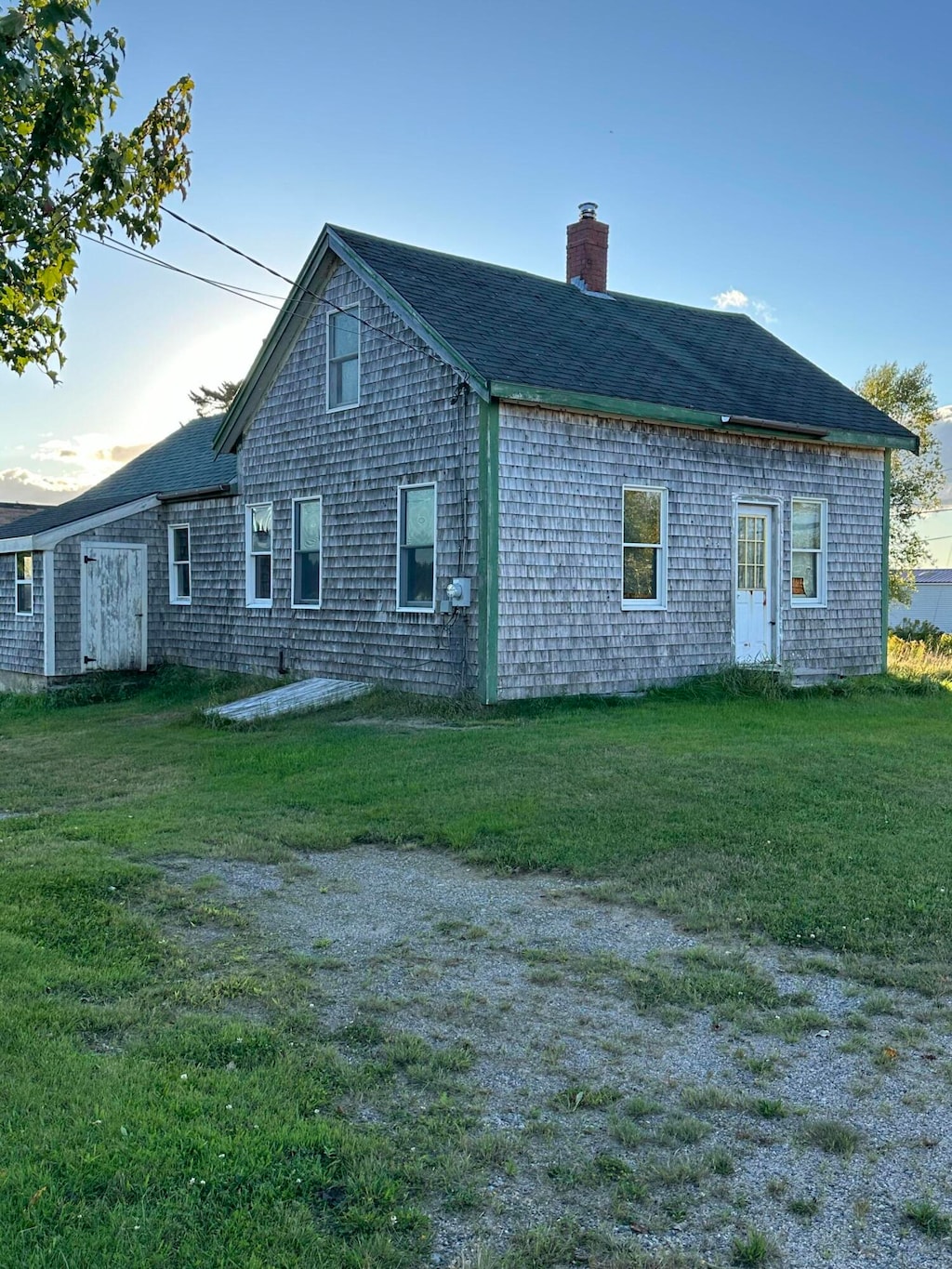 back house at dusk featuring a yard