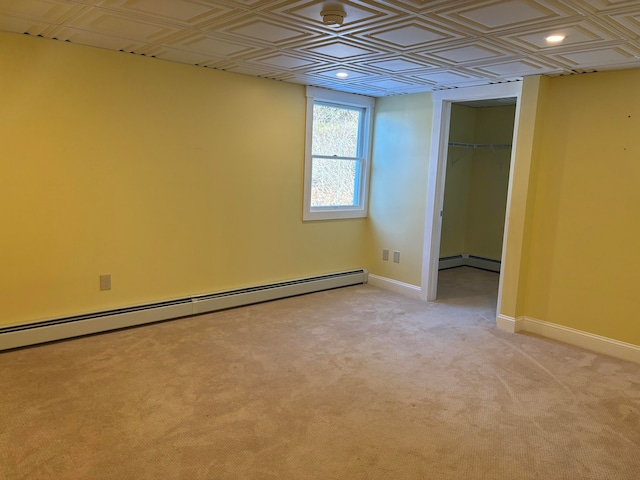 spare room with light colored carpet and baseboard heating