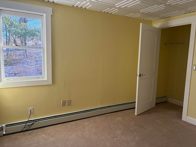 empty room featuring baseboard heating and light carpet