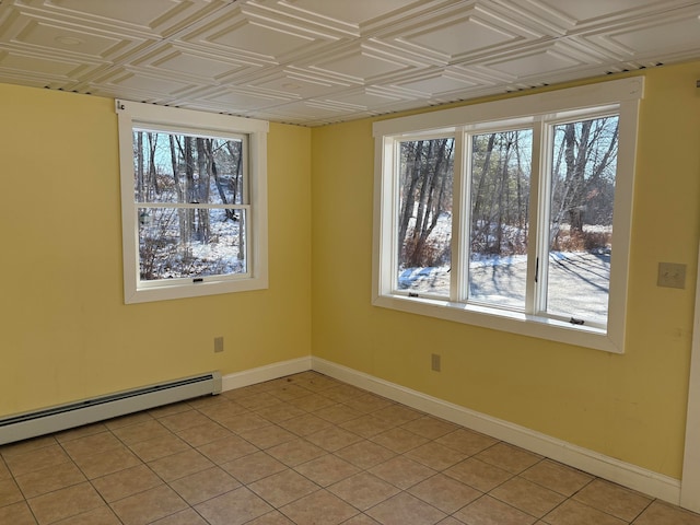 empty room with light tile patterned floors, a healthy amount of sunlight, and a baseboard radiator