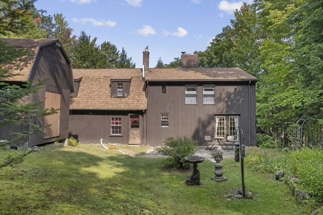 back of property with french doors and a lawn