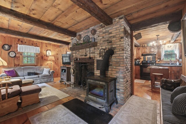 living room featuring wooden ceiling, a wealth of natural light, and a wood stove