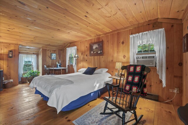 bedroom featuring light wood-type flooring, vaulted ceiling, wooden walls, and wood ceiling