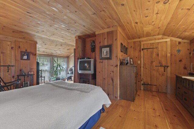 bedroom with wood walls, wooden ceiling, and light hardwood / wood-style floors