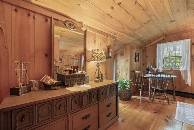 interior space featuring wood-type flooring, wood ceiling, wooden walls, and vaulted ceiling