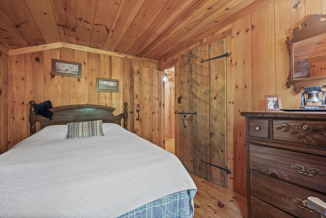 bedroom featuring light wood-type flooring, wood walls, lofted ceiling, and wooden ceiling