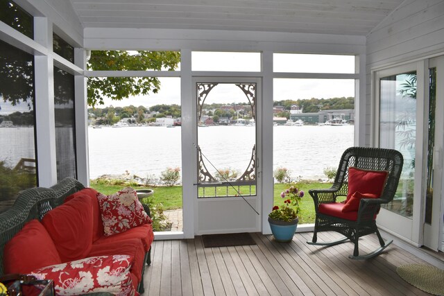 sunroom featuring lofted ceiling and a water view