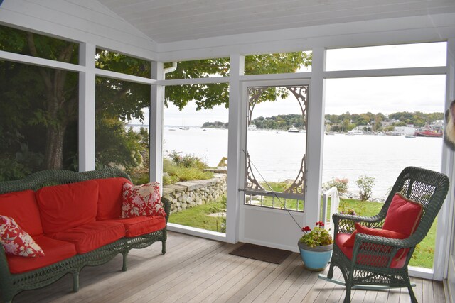 sunroom featuring lofted ceiling and a water view