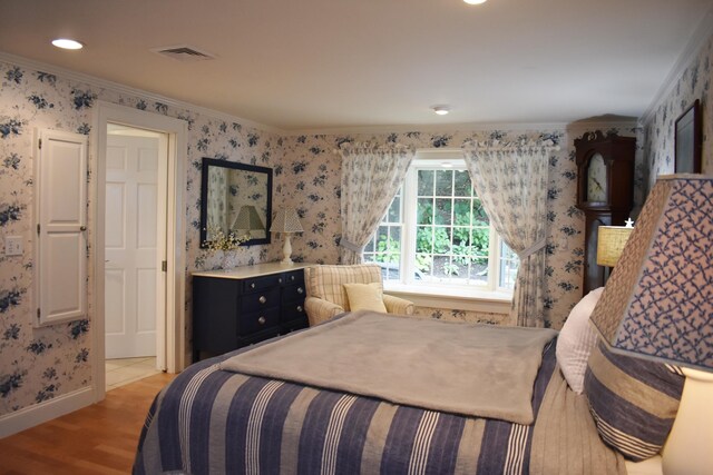 bedroom featuring light hardwood / wood-style flooring and ornamental molding