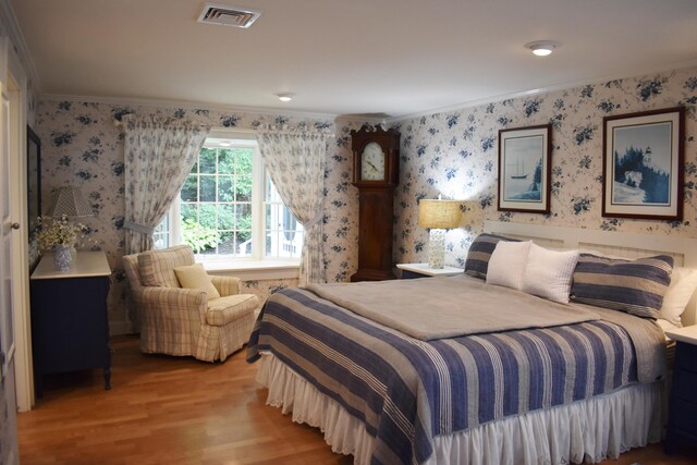 bedroom with light wood-type flooring and ornamental molding