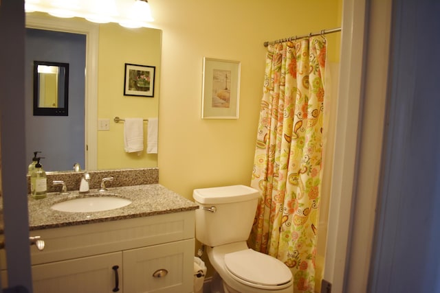 bathroom featuring a shower with shower curtain, vanity, and toilet