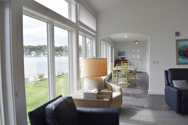 tiled living room with a water view and a wealth of natural light