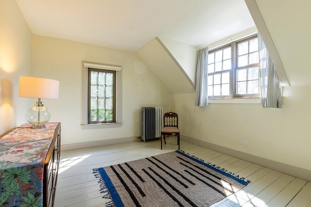 bonus room featuring radiator heating unit and light hardwood / wood-style flooring