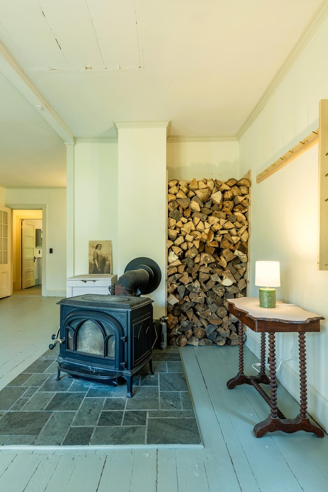 interior space with hardwood / wood-style flooring, a wood stove, and ornamental molding