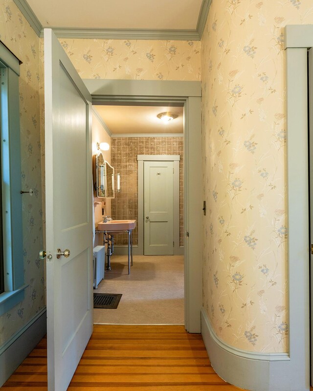 hall with crown molding and hardwood / wood-style floors