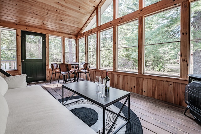 sunroom with wood ceiling, plenty of natural light, and a wood stove