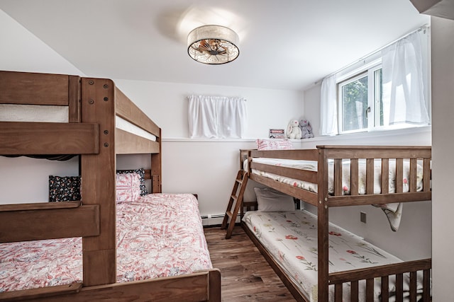 bedroom with baseboard heating and dark hardwood / wood-style flooring