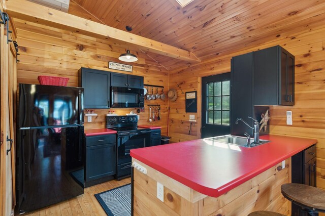 1270 Lakeview Dr Unit 23, China, ME 04358 - kitchen featuring black appliances, a sink, light wood-style flooring, wood walls, and a breakfast bar area