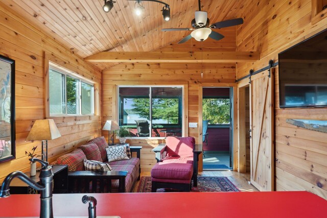 1270 Lakeview Dr Unit 23, China, ME 04358 - living area featuring a barn door, healthy amount of natural light, wood walls, lofted ceiling, and a ceiling fan