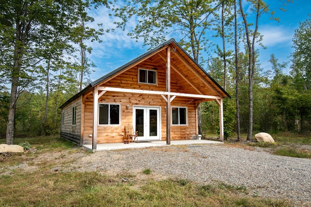 407 Pleasant River Rd, Milo, ME 04463 - rear view of house with log veneer siding and french doors