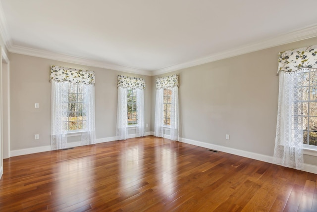 spare room with plenty of natural light, ornamental molding, and hardwood / wood-style flooring