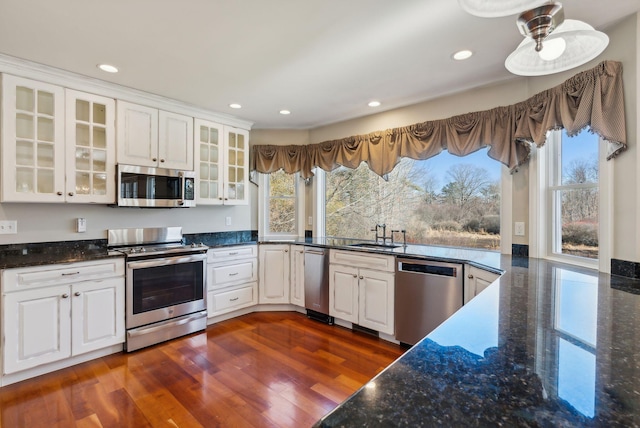 kitchen with appliances with stainless steel finishes, dark wood-style flooring, and white cabinetry