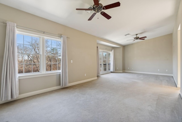 carpeted empty room with visible vents, baseboards, and a ceiling fan