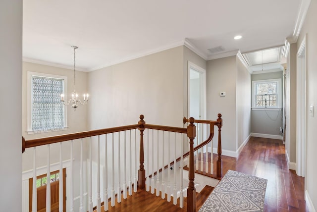 hallway featuring an upstairs landing, wood finished floors, crown molding, baseboards, and attic access