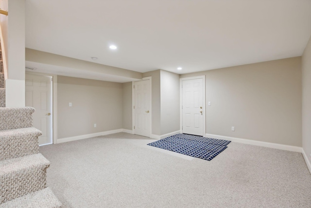 finished basement with recessed lighting, light colored carpet, stairs, and baseboards