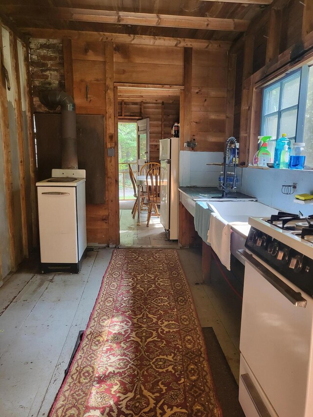 kitchen featuring washer / dryer, white appliances, and a wealth of natural light