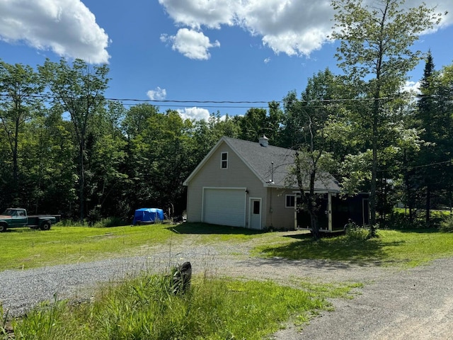 view of side of home featuring a yard and a garage