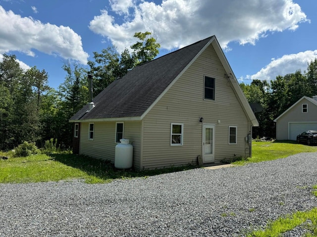 view of side of property with an outbuilding, a lawn, and a garage