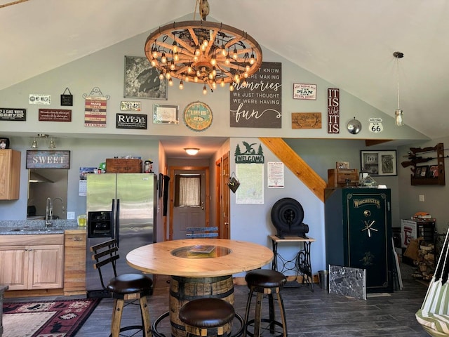 dining space with dark wood-type flooring, a chandelier, high vaulted ceiling, and sink