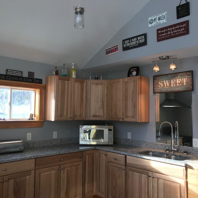 kitchen featuring lofted ceiling, hanging light fixtures, and sink