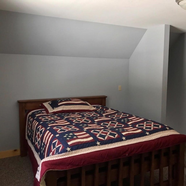 carpeted bedroom with lofted ceiling